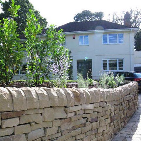 Beautiful York Stone dry wall with plant borders and evergreen shrubs