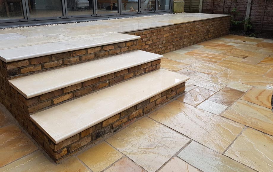 Fossil Mint Indian Sandstone patio and retaining wall in reclaimed London Stocks